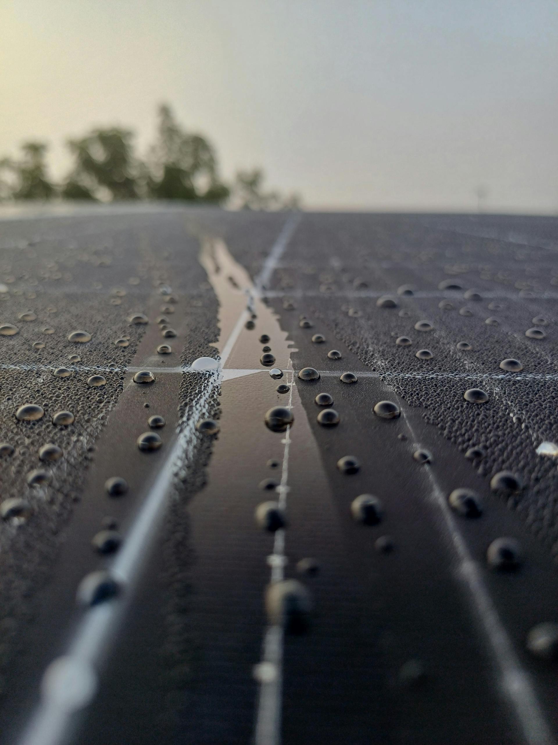 Dew droplets on solar panel in São João do Piauí, Portugal, reflecting morning light.
